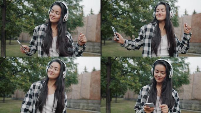 好看的亚洲学生在户外跳舞的耳机中享受音乐