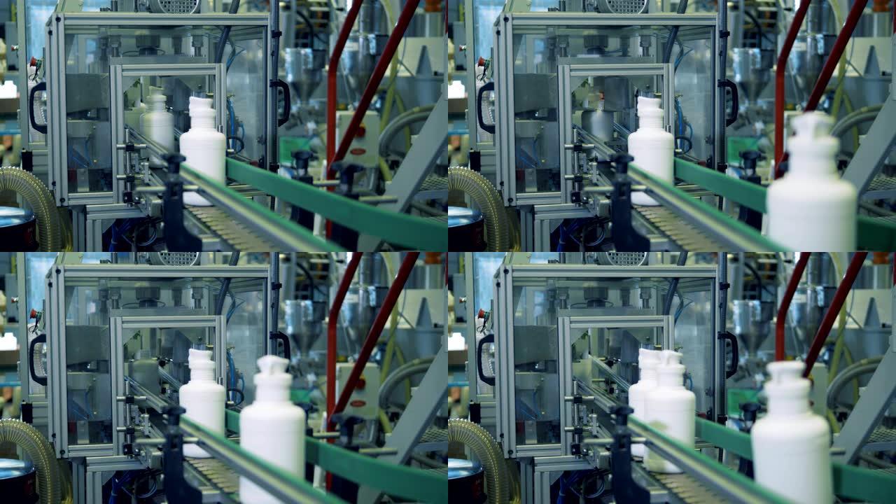 工厂输送机上带有化学药品的白色瓶子，自动技术。