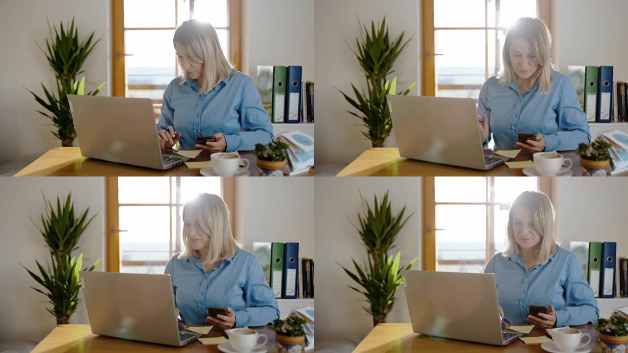 DS女商人在家工作时使用智能手机和笔记本电脑