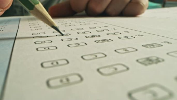 考试时，人用铅笔给正确的答案上色。用标准化测试填充答题纸，标记正确的答案气泡