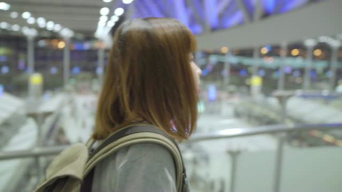 年轻的亚洲背包客女游客在国际机场散步。