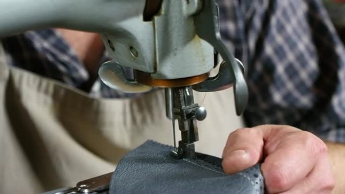 工匠在缝纫机上缝制皮革的手