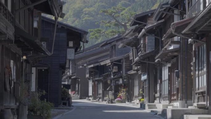 身份不明的人参观了日本长野木曾谷的日本奈莱邮政镇旧木屋和狭窄的街道。(Narai-Juku)