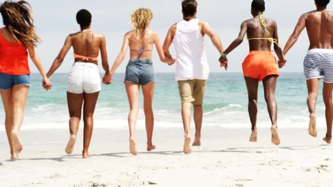 一群混血朋友在沙滩上携手奔跑4k