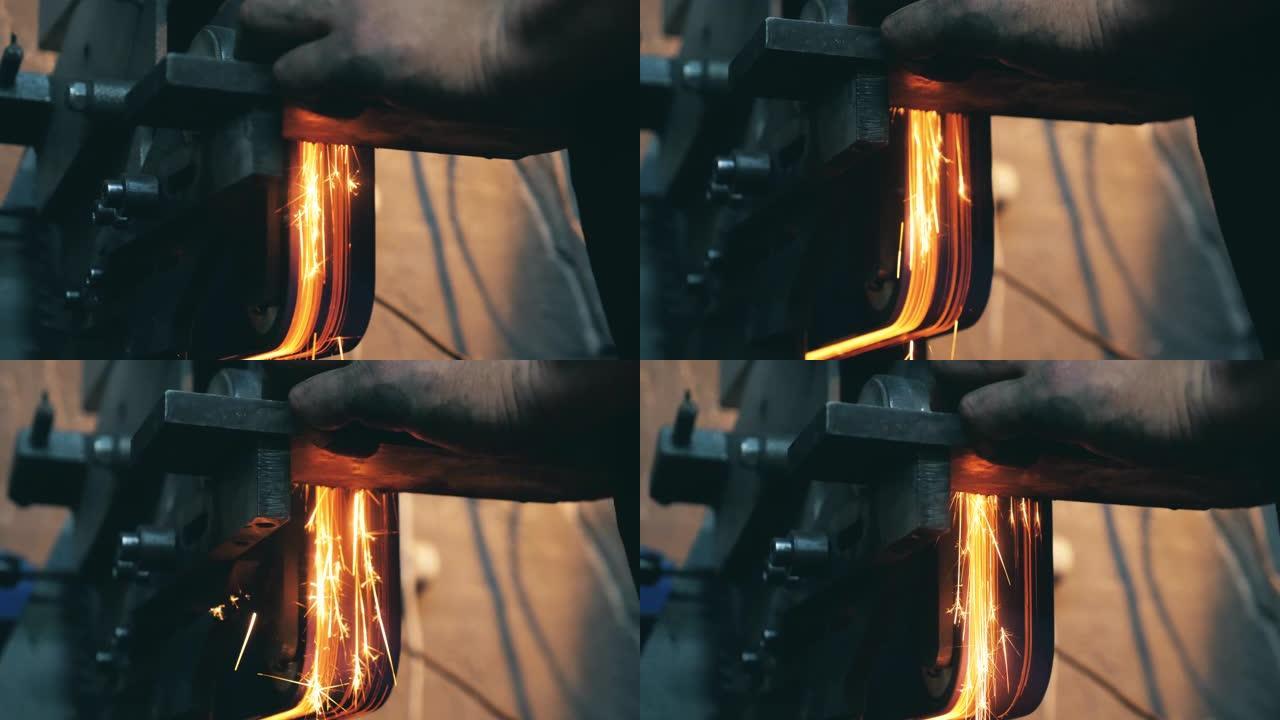 铁匠在锻造厂工作时使用角磨机。