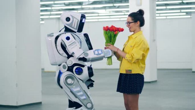 机器人给一个女孩红色的郁金香，她拥抱它。