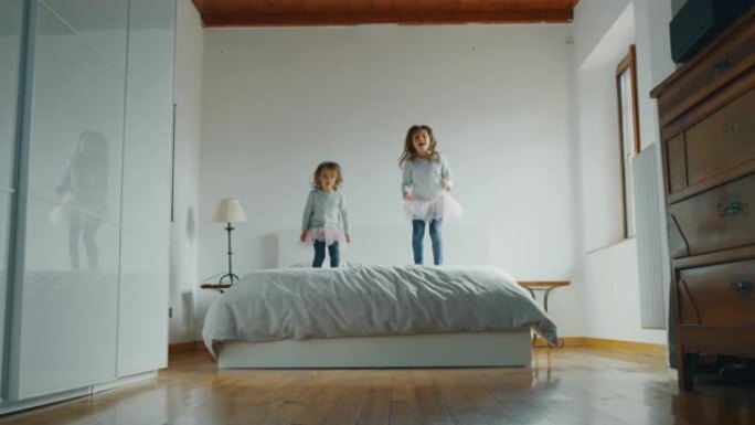 皮皮亚玛和粉色短裙小女孩在床上跳跃的真实照片
