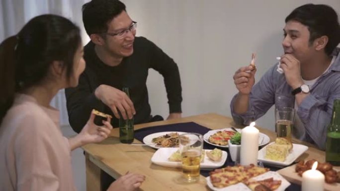 4k解决方案亚洲朋友在圣诞晚宴上玩得开心。快乐的泰国人在家里的聚会上一起吃披萨。