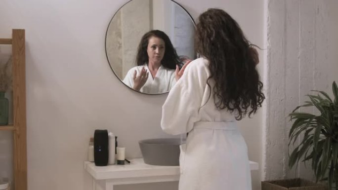 漂亮女人洗脸看浴室镜子