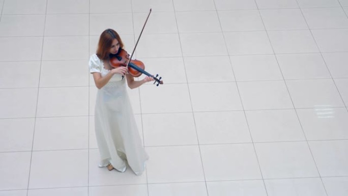 白色地板，一位女士站在上面拉小提琴