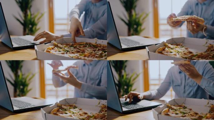 DS女人在家里用笔记本电脑工作时吃了一块披萨
