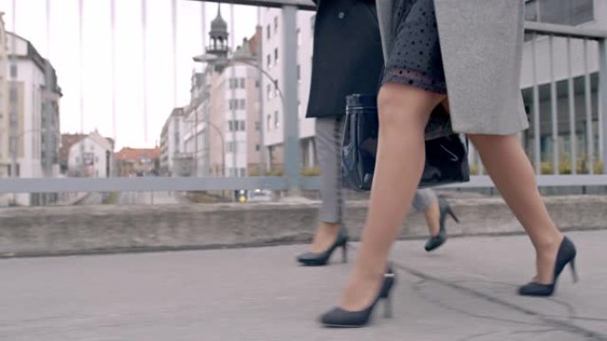MS商业女性穿着高跟鞋走在城市人行桥上