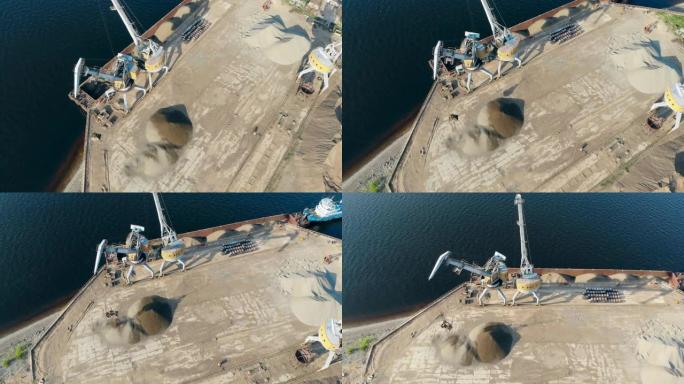 工作起重机在港口用瓦砾在水上卸下驳船。