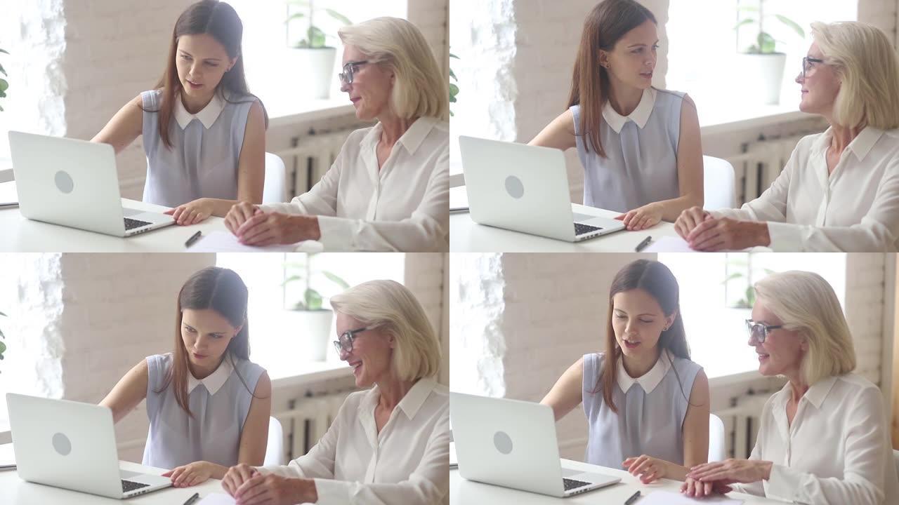 年轻的女售货员保险公司咨询看笔记本电脑的老女性客户