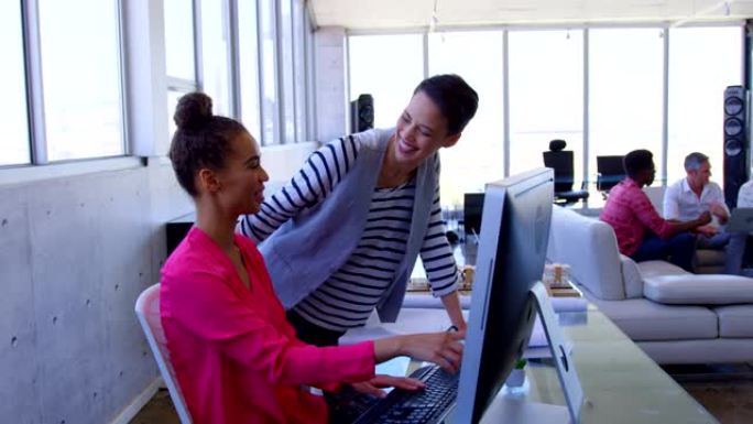 美丽的多民族商务女性讨论个人电脑在现代办公室4k