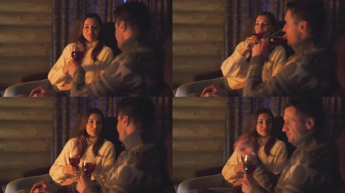 在壁炉旁喝酒的男人和女人