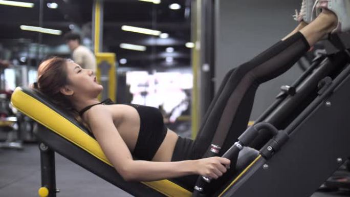 亚洲女性在健身房做腿部按压运动