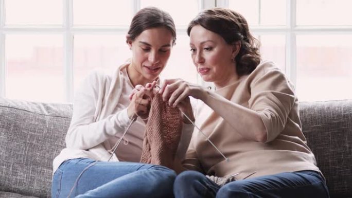 快乐成熟的妈妈教年轻的成年女儿学习编织