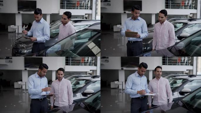 友好的推销员向男性顾客展示汽车，同时拿着剪贴板解释汽车的特性