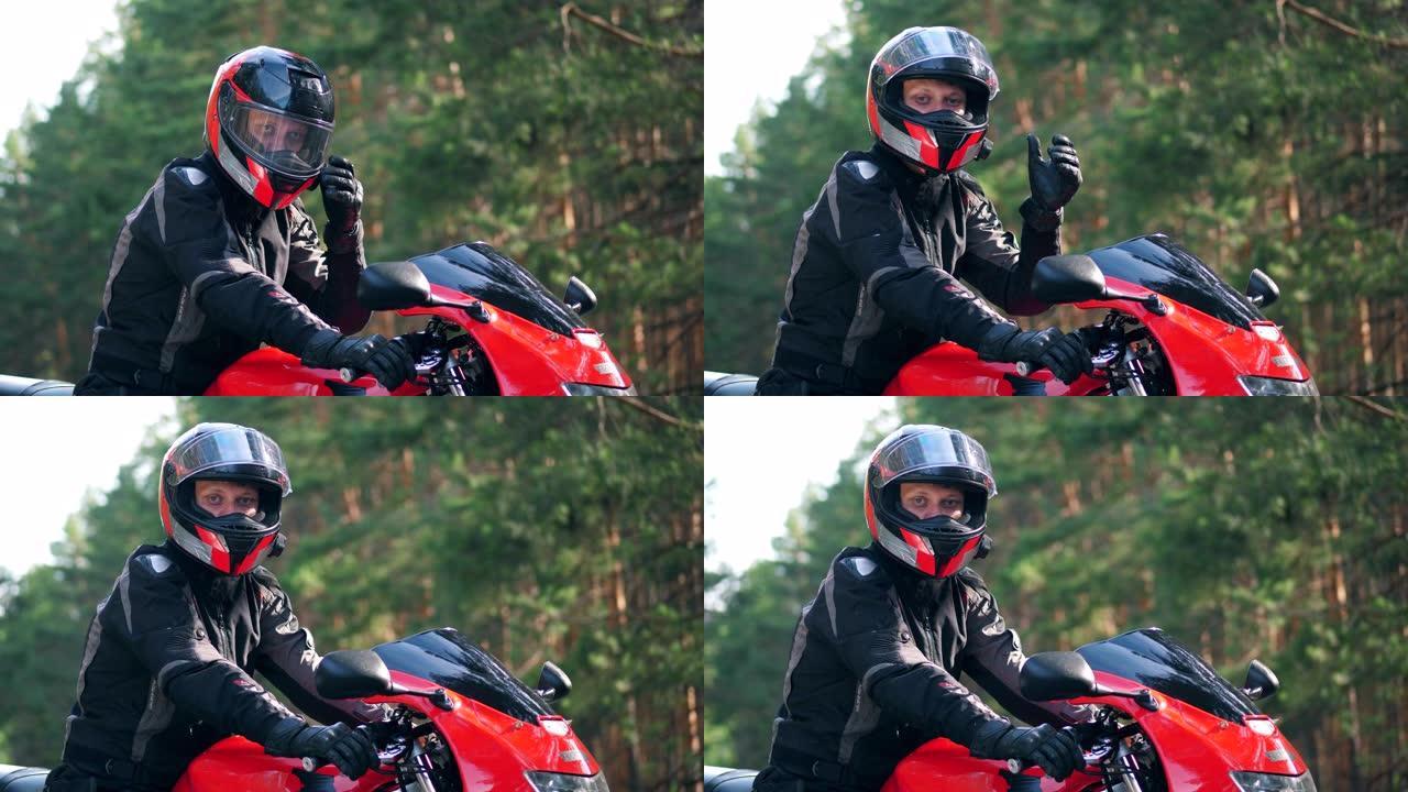 戴着头盔的男性骑自行车的人坐在摩托车上，看着相机。