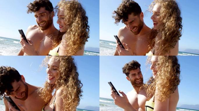 浪漫情侣在海滩4k使用手机