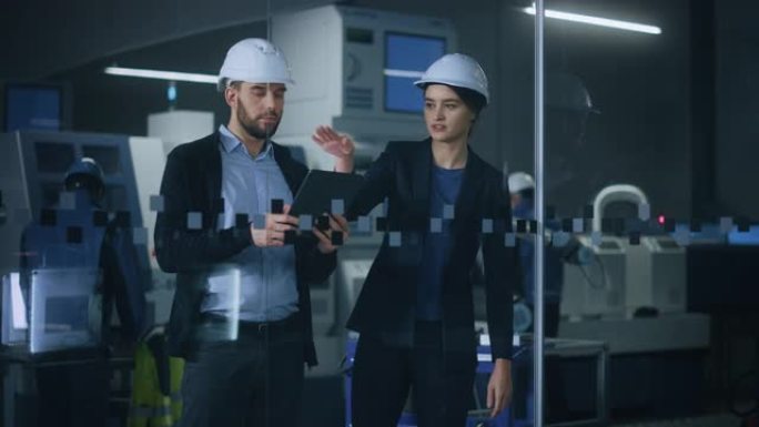 现代工厂: 女项目经理，男工程师站在高科技开发设施中，交谈和使用平板电脑。拥有数控机械、机械臂生产线