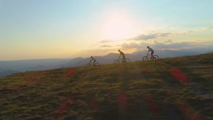无人机: 在阳光明媚的春日，一群山地自行车手在草木山上加速行驶。