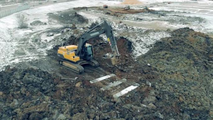 挖掘机沿着采石场行驶。挖掘机在建筑工地挖土。