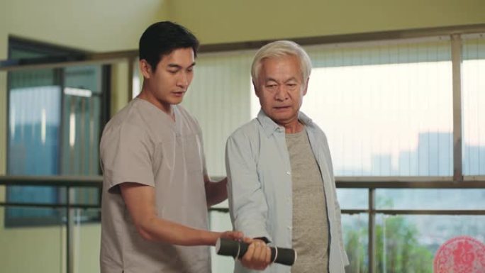 年轻的亚洲物理治疗师与高级患者一起工作