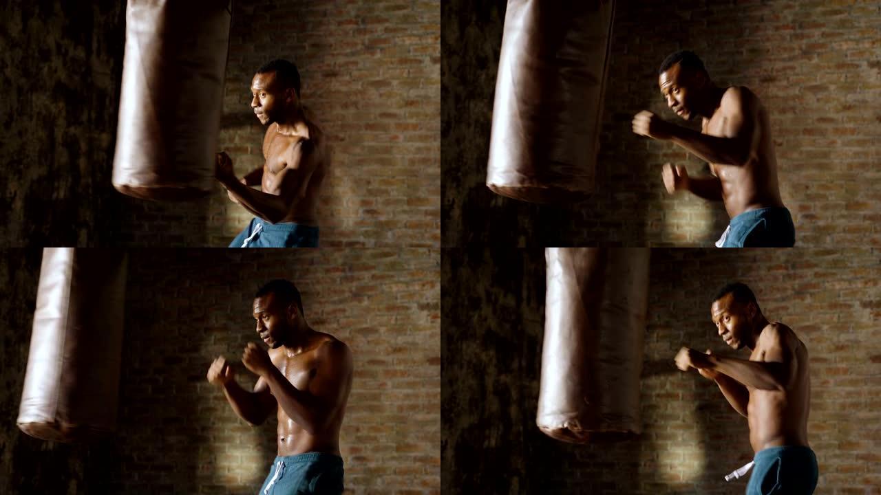 一个非裔美国人在老式健身房训练，用拳头打他的拳击袋拳头。