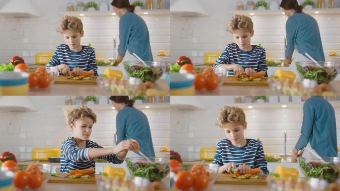 在厨房里: 可爱的小男孩为健康晚餐切蔬菜的肖像。男孩养成健康的习惯，吃很多沙拉和蔬菜。在背景中，妈妈