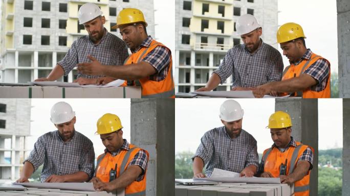 工头和建筑工程师讨论未完建筑中的蓝图