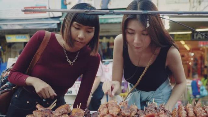 两名年轻女子在考山路享受街头美食。