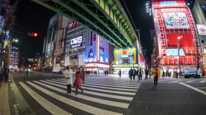 人们步行的4k时间流逝在日本东京的秋叶原的街道交叉路口与汽车交通交叉路口。日本文化与电城购物区概念