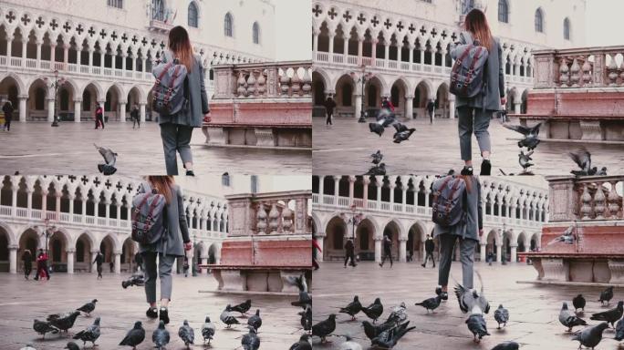 在意大利威尼斯令人惊叹的老城广场上，一大群鸽子跟随带着背包的快乐女游客慢动作