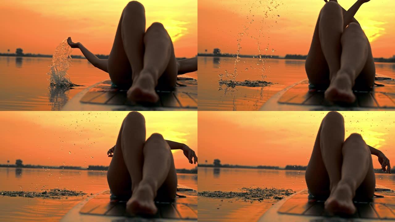 超级SLO MO女冲浪板溅水在日落