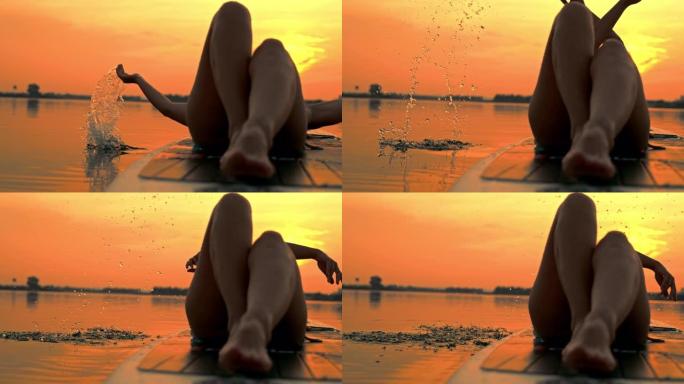 超级SLO MO女冲浪板溅水在日落