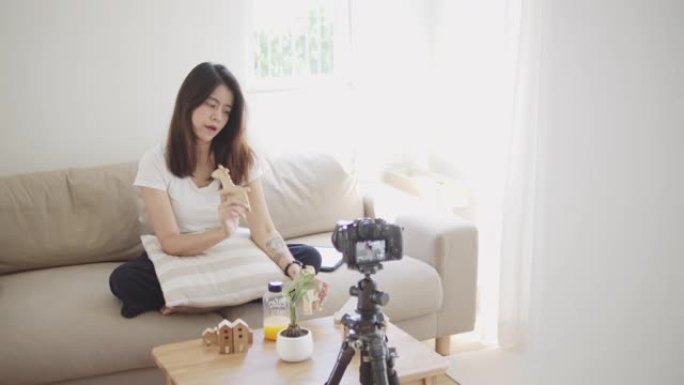亚洲女性博客作者用相机录制视频并在家里聊天