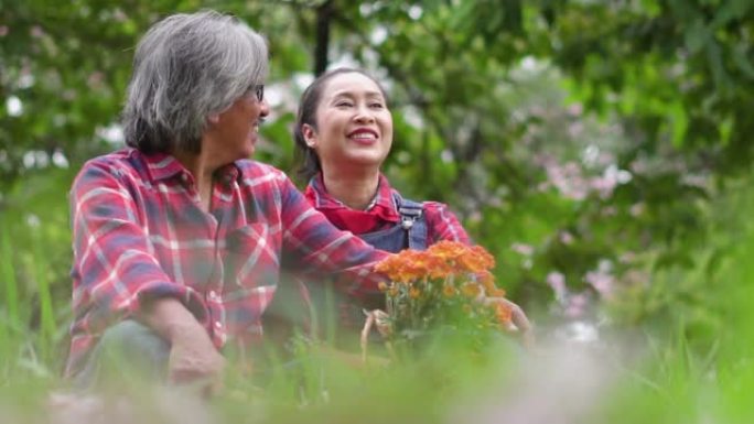 慢动作: 高级农民夫妇在花园里坐着和幸福交谈。