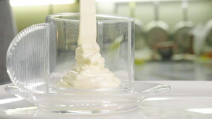 专业的糖果商通过在盆中击败新鲜鸡蛋b í o来制作蛋糕来准备奶油。