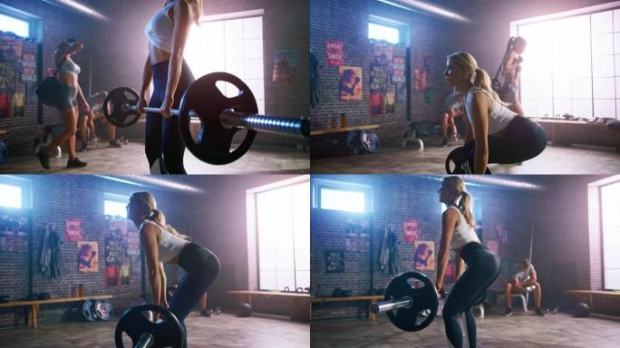 美丽健康的运动金发女性从地面上举起杠铃，做背部强化锻炼，作为她日常的健身训练程序。她在阁楼健身房和运
