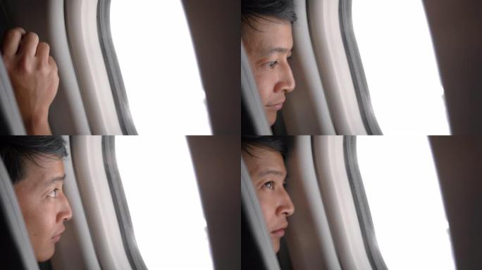 亚洲男子打开飞机上的窗户