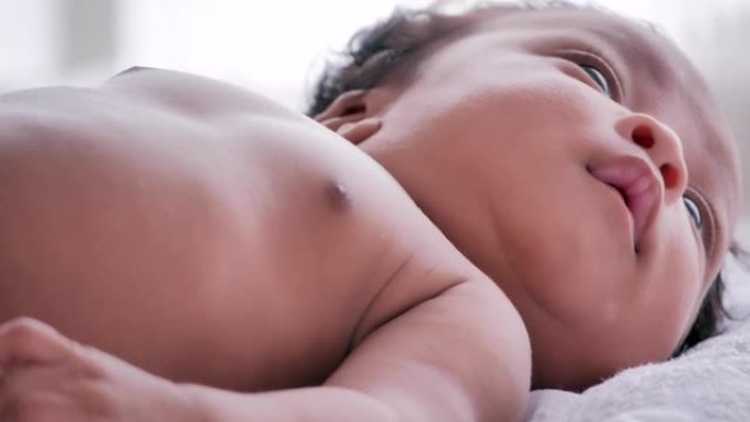 近景拍摄的新生儿非洲民族年龄1个月在家床上休息。家庭时刻概念。