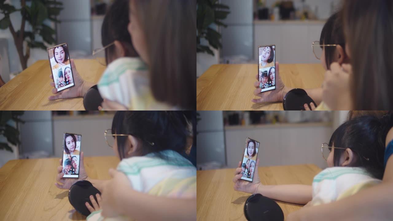 亚洲家庭使用电话，通过在家中的视频通话与朋友聊天