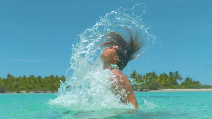 特写: 快乐的旅游女孩用她棕色的长发溅海水。