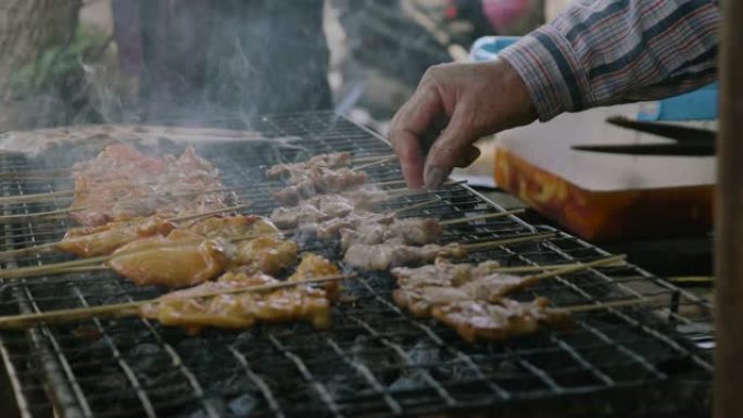 串鸡肉块在烤架上烤，冒烟