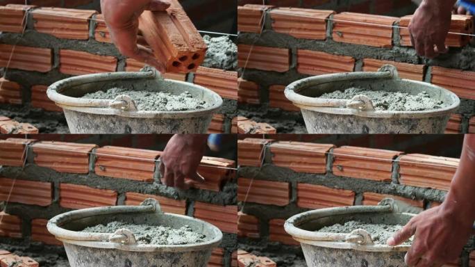 4k镜头特写手工专业建筑工人在新工业场地、建筑行业和砖石概念中砌砖的场景