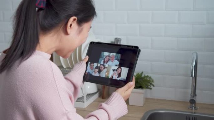 亚洲妇女在家工作时，在家厨房里通过视频通话网络摄像头与家人交谈。自我隔离，社交距离，检疫保护冠状病毒
