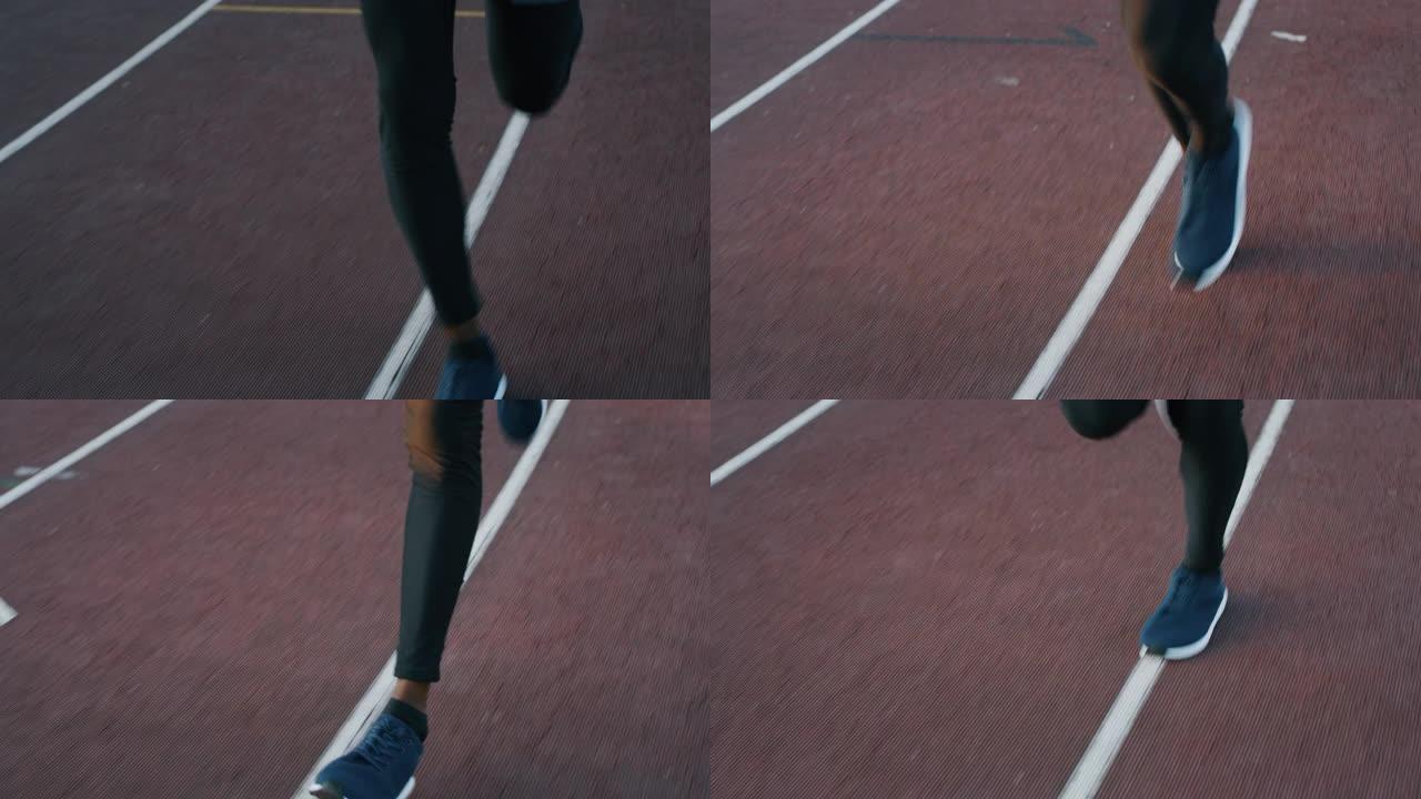 年轻的非洲男运动员的慢动作在体育馆的赛道上奔跑
