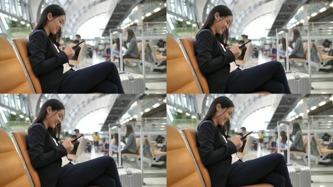 在机场候机室使用手机的妇女
